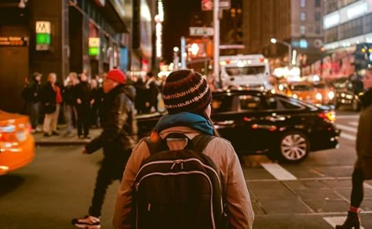 choose to live. woman with a backpack crossing a city street.