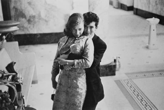 hugging couple looks coyly at the camera