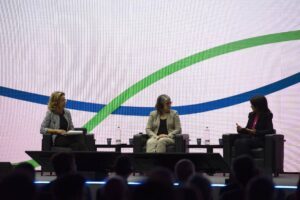 Three women sitting on stage in chairs in a panel conversation