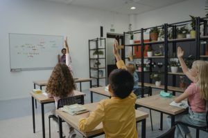 students raising hand in a classroom