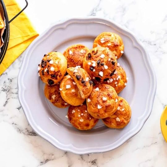 Pearl sugar and chocolate chouquettes on a white plate.