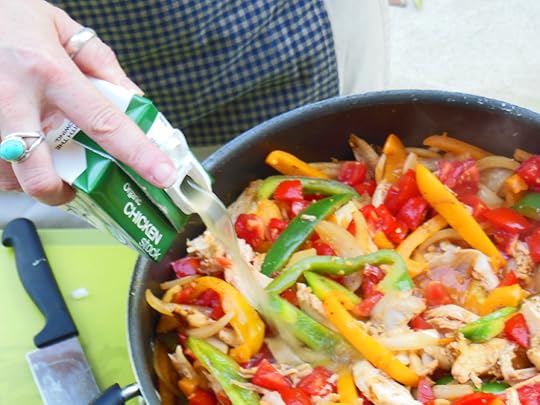 Adding organic chicken broth to fajita ingredients.