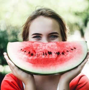 Girl holding a grinning watermelon 