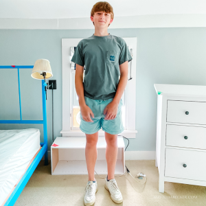 William stands in his empty bedroom with his head almost touching the ceiling