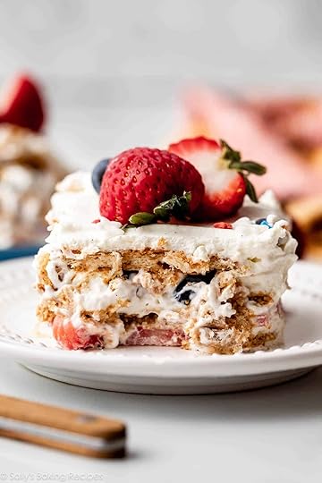 slice of berry icebox cake with vanilla whipped cream between the layers on white plate.