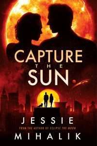 Silhouette of a couple backlit by an orange/yellow sun but at night, all the light shed is dark red apart from the sun itself with a cityscape in the background. 