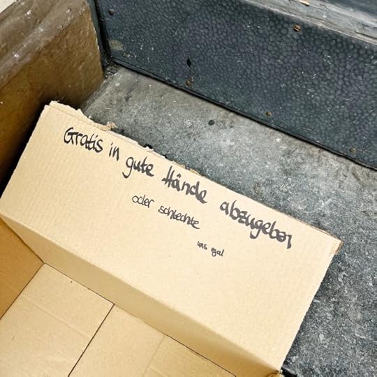 Ein Pappkarton auf einer Treppe, auf dem Deckel steht 