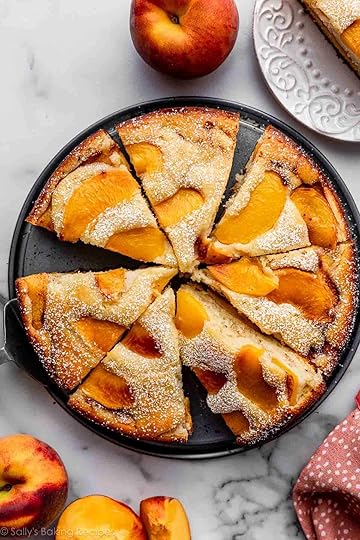 peach cake cut into slices sitting on bottom of springform pan.