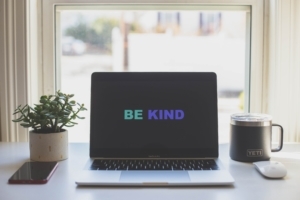 This writing desk setup has a message on the computer screen reminding you of writing kindness—