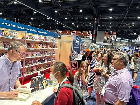 An author signing books at ALA 2023 in Chicago.