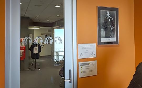 The entrance to the shop building at Scott Base, with a photograph of the station's namesake and the Antarctica New Zealand logo on the glass door.