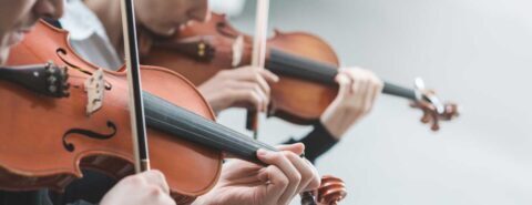 Two people playing violins together illustrating the blog post 