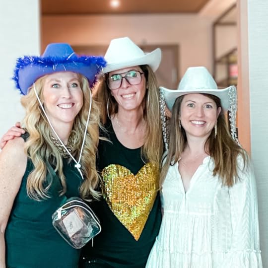 Amy Julia and two friends wear cowboy hats and smile for the camera