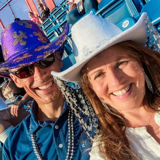 Peter and Amy Julia wear cowboy hats and smile for a selfie as they sit in stadium seating