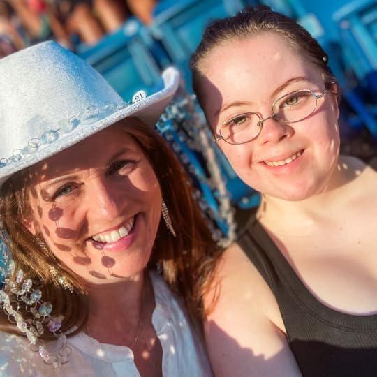 Amy Julia and Penny smile for a selfie as they sit in stadium seating