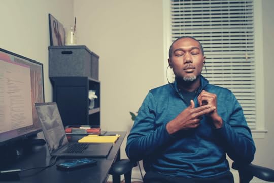 Man at desk with eyes closed using The Tapping Solution app to do a guided EFT Tapping back pain meditation