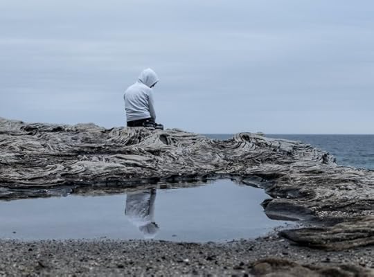 Face your fears or live life afraid? The choice is yours to make. Person on rocks between a natural pool and the ocean.