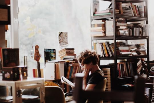woman reading historical fiction in a room of books