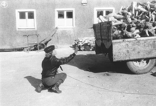 Life magazine photographer Margaret Bourke-White prepares to take a photograph of a wagon piled with corpses in the newly liberated Buchenwald concentration camp.