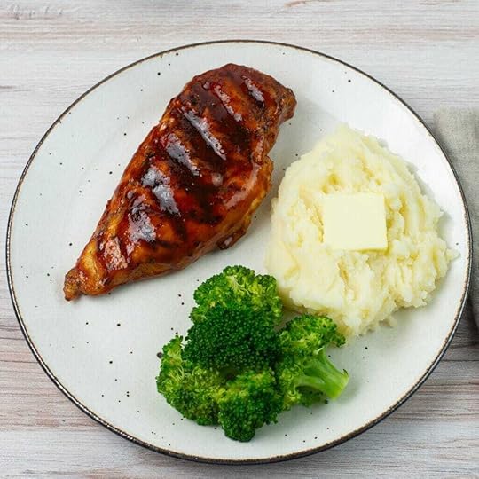 Honey Buffalo BBQ sauce used to glaze a grilled chicken breast served on a plate with potatoes and broccoli.