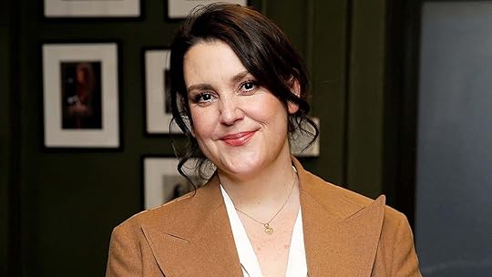 Melanie Lynskey in a brown blazer soft smiles on the carpet in New York City