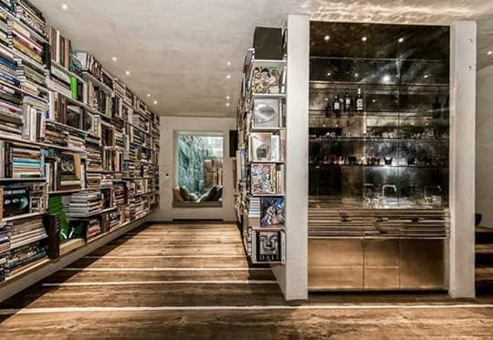 A room with a wall of booksDescription automatically generated