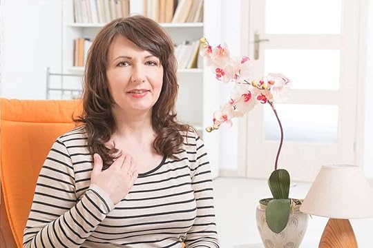 Woman sitting in chair tapping on the collarbone point, doing EFT Tapping meditation