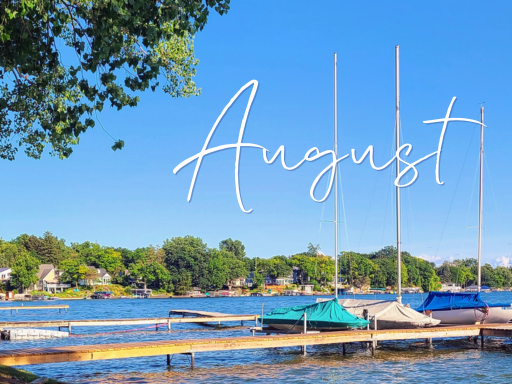 Lake with trees, a dock, and sailboats. Text saying August