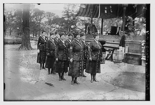 A black and white photograph of a group of women in uniform standing in front of a building.
