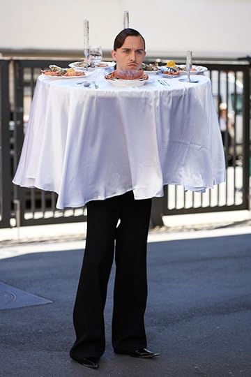Man dressed up as dinner table with food on it.