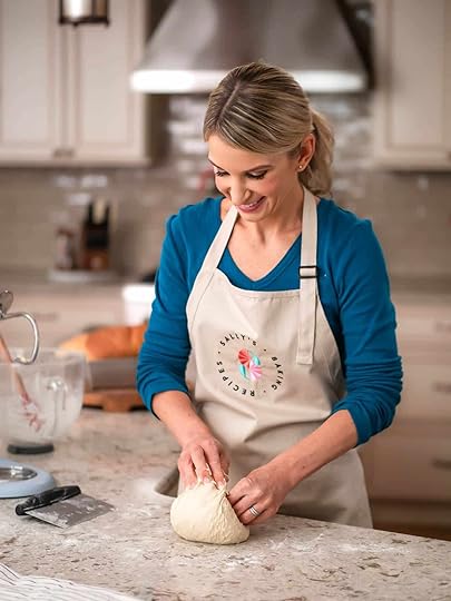 Sally wearing blue shirt and khaki branded apron working with dough on counter.