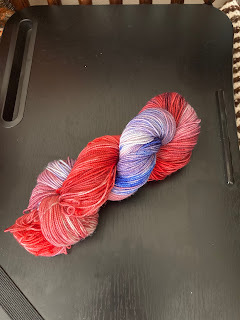 a skein of yarn shading from red to blue, passing briefly through purple. Looks like one of those red/white/blue popsickles you can get from ice cream trucks.