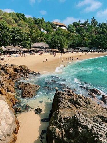 View of a rocky and sandy beach in Mexico, blue sky behind. From 5 Reasons Why Mexico Is The Ultimate Vacation