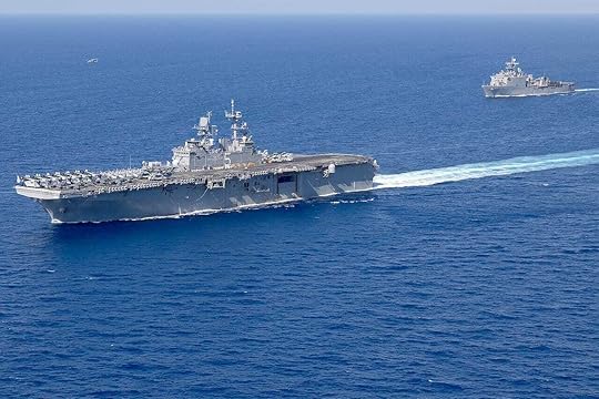 Two military ships move though the ocean.