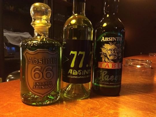 Three different bottles of absinthe on a bar