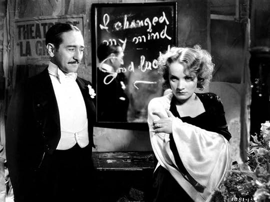 Marlene Dietrich stands in front of a mirror on which is written