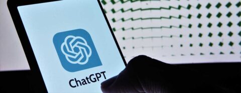 Close up of a hand holding a mobile device with ChatGPT text and logo on screen, to illustrate the blog post 