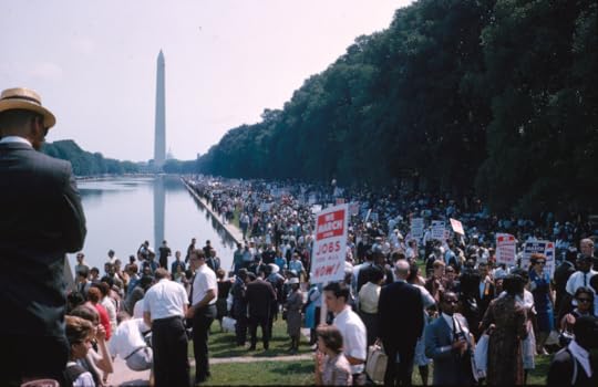 People holding signs at the Lincoln Memorial Reflecting Pool with the Washington Monument in the distance during the March on Washington