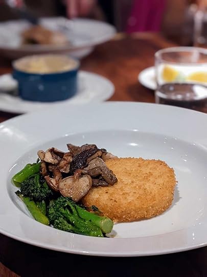 A cake of grits topped with mushrooms and greens at Chemin a la Mer in New Orleans