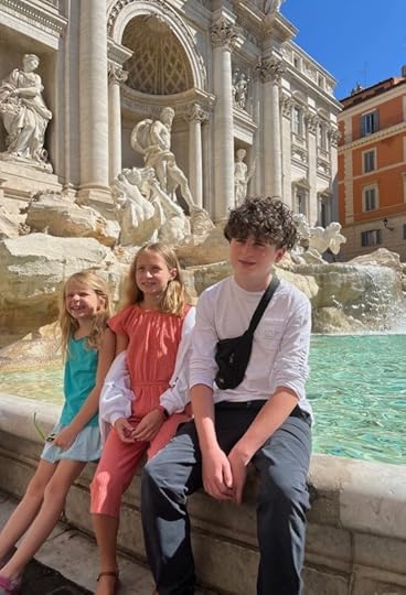 kids sitting in front of the Trevi Fountain