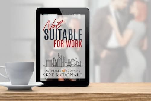 Ebook on a mobile tablet beside a cup of coffee on a wooden table.