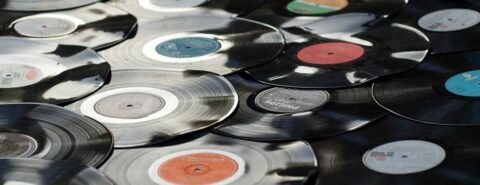 Black vinyl records layered over a flat surface to illustrate the blog post 