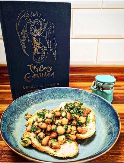 The Books of Earthsea next to a delicious plate of food