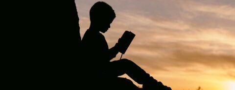 Silhouette of a child reading a book to illustrate the blog post 
