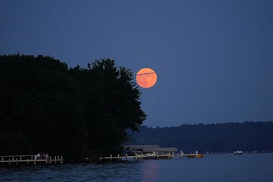 Rare strawberry moon appears over green lake, wisconsin