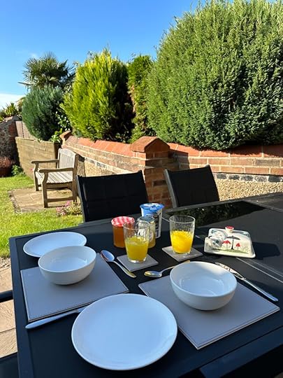 Photo shows a table outside set for breakfast. 