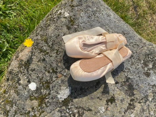 golden and blue: ballet shoes on a stone
