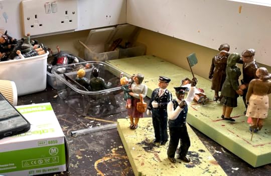 Bekonscot Model Village figures workshop; minature people stand on foamboard while paint dries, others like in Tupperware boxes