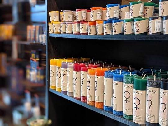 Colorful candles for spell casting lined up on a shelf at a Salem witch shop