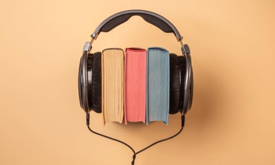 heaphones wrapped around yellow, red, and blue hardcover books, Recent Audiobook Trends Going Into Fall 2023